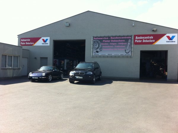De gevel van Autoservice Debackere met de rode borden in Izegem